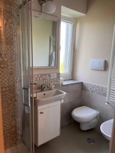 ein Badezimmer mit einem Waschbecken, einem WC und einem Spiegel in der Unterkunft L'Antico Gelso in Viggiano