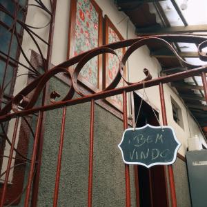 a sign that says be in mind hanging on a gate at Nuh Hostel in Ouro Preto