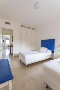 ラスパルマス・デ・グランカナリアにあるCanary Islands Holidaysの白いベッドルーム(ベッド2台、青いヘッドボード付)