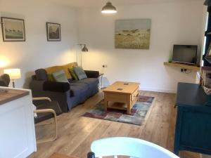 a living room with a couch and a coffee table at Mendip Cottage in Shipham