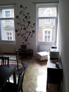 a living room with a table and two windows at Anna 2 bedrooms 2 bathrooms 6 bikes in Budapest