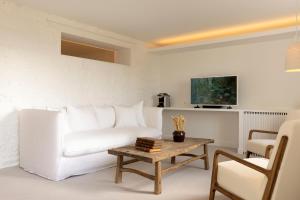 a living room with a white couch and a coffee table at Ô PLUM'ART Chambres de caractère in Giverny