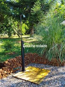 una luz de la calle en un paseo marítimo de madera en un jardín en Chalet "Le Petit olivier" gîtes appart 'hôtel L'ÉCHAPPÉE BELLE D'AUBENAS Logement 2 sur 3, en Aubenas