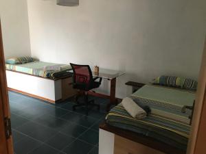 a room with two beds and a desk and a chair at Beach Rotxa in Vila do Maio