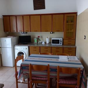 eine Küche mit einem Tisch, einem Herd und einer Mikrowelle in der Unterkunft La Casa di Walter in Levanto