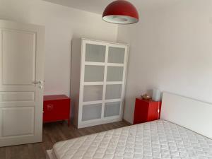 a bedroom with a white bed and a red cabinet at Свети Йоан in Sozopol