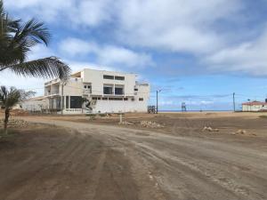 a white house on the side of a dirt road at Beach Rotxa in Vila do Porto