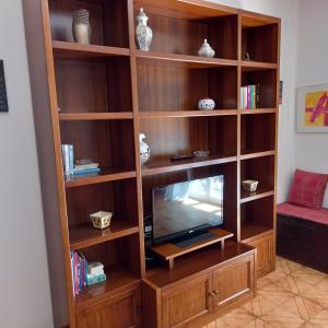 une étagère en bois avec une télévision à l'intérieur dans l'établissement La Casa di Walter, à Levanto