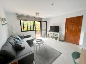 salon z kanapą i stołem w obiekcie Corralejo Happy Place, precioso apartamento con piscina w Corralejo