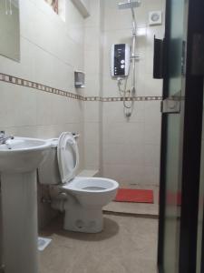 a bathroom with a toilet and a sink at Logmma Regency Hotel in Kakamega