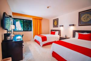 um quarto de hotel com duas camas e uma televisão de ecrã plano em Eco City Hoteles em Tuxtla Gutiérrez