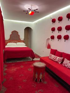 a bedroom with a red bed and a red couch at Riad Miliana in Marrakesh