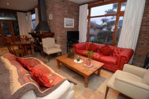 a living room with a red couch and a table at Aitue Apart Hotel & Spa in Valeria del Mar