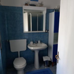 ein blau gefliestes Bad mit WC und Waschbecken in der Unterkunft La Casa di Walter in Levanto