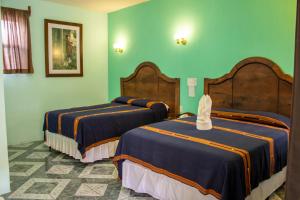 2 camas en una habitación con paredes verdes en Hotel Casa Texel, en Panajachel