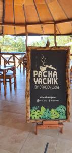 una señal para un restaurante con mesa y sillas en Hosteria Orkidea Lodge, en Puyo