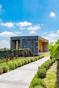 a modern house with a stone facade at Casa Raíces Hotel Luxury & Viñedo in Los Galvanes