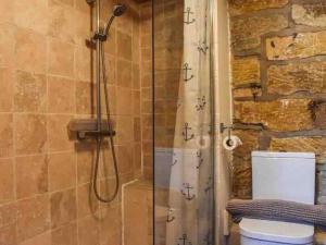 uma casa de banho com chuveiro e WC em Cosy 400 yr old Cottage, Flowergate, Whitby em Whitby