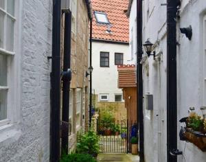 an alley between two buildings with at Cosy 400yr old Cottage, Flowergate, Whitby, Sleeps 6 in Whitby