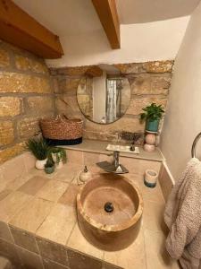 a stone bathroom with a sink and a mirror at Cosy 400 yr old Cottage, Flowergate, Whitby in Whitby