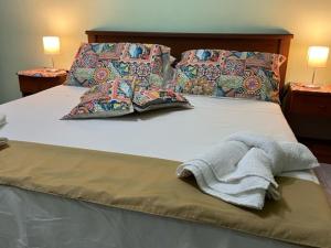 uma cama com um cobertor e almofadas em Holiday Gole Alcantara Graniti Room em Graniti