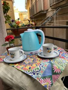 um bule de chá azul e duas chávenas numa mesa em Holiday Gole Alcantara Graniti Room em Graniti