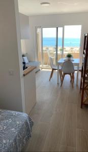 a bedroom with a table and a dining room with the ocean at Apartamento Con Vistas Al Mar - WIFI - Aire Acondicionado in Empuriabrava