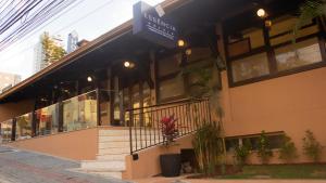 una tienda frente a un edificio con un cartel. en Essência Hotel Francisco Beltrão en Francisco Beltrão