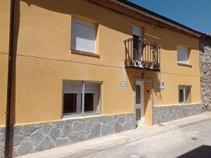 ein Gebäude mit einem Balkon mit Flaggen darauf in der Unterkunft Casa Rural Estajero in Muñana