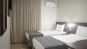 Cama ou camas em um quarto em Essência Hotel Francisco Beltrão
