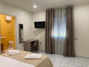 Televízia a/alebo spoločenská miestnosť v ubytovaní Akoya Rooms Capo Vaticano