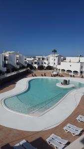 une grande piscine au milieu d'un complexe dans l'établissement New Pistachio Apartment, à Costa Teguise