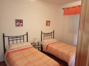 1 dormitorio con 2 camas y mesa en Casas Manolo en Vejer de la Frontera