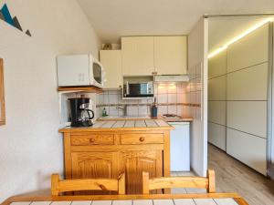 eine kleine Küche mit einer Theke und einer Mikrowelle in der Unterkunft Studio Flaine, 1 pièce, 4 personnes - FR-1-425-154 in Flaine