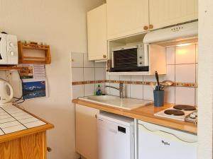 eine kleine Küche mit einer Spüle und einer Mikrowelle in der Unterkunft Studio Flaine, 1 pièce, 4 personnes - FR-1-425-154 in Flaine