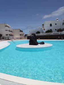 a pool with a rock in the middle of the water at New Pistachio Apartment in Costa Teguise