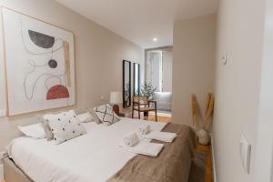 a bedroom with a large white bed and a chair at Almada 1.3 by LovelyStay in Porto