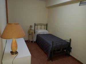 1 dormitorio con 1 cama y 1 lámpara en una mesa en Appartamento piano terra, en Montallegro