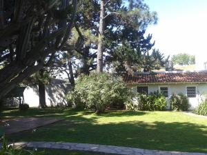 uma casa com um quintal com relva verde e árvores em Casa Suiza em Luis Guillón
