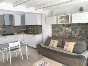 a living room with a couch and a table and a kitchen at Pipa House in San Donato di Lecce