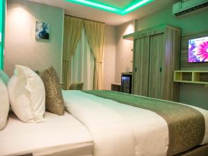 a bedroom with a large white bed and a television at شقق روند للشقق الفندقية in Hafr Al-Batin
