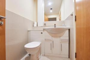 a white bathroom with a toilet and a sink at Lovely flat in central Manchester in Manchester