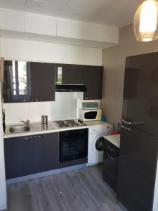 Una cocina con estufa, fregadero y microondas. en Studio BANDOL, en Bandol