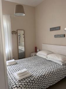 1 dormitorio con 1 cama grande y toallas. en L'Antico Gelso, en Viggiano