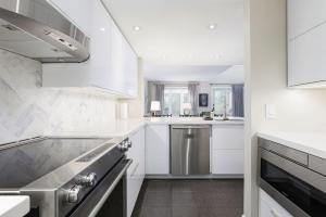 a kitchen with white cabinets and stainless steel appliances at Steps to Blue Mtn Condo wt Elegant Style 213 Sierra Lane in Blue Mountains