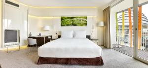 a bedroom with a large white bed and a desk at Radisson Blu Hotel & Convention Centre Kigali in Kigali
