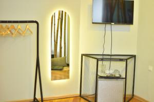 a living room with a television and a lamp at Boutique Hotel Medusa in Batumi
