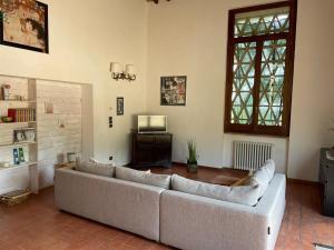 sala de estar con sofá y TV en Alto Locandieri, en Montebagnolo