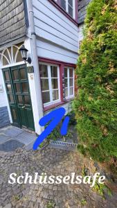 une maison avec un banc bleu devant une porte dans l'établissement Tradition Monschau 3, à Monschau