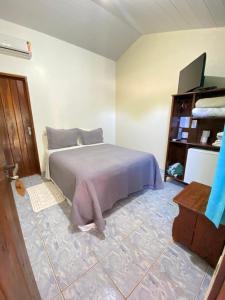 a bedroom with a bed and a wooden cabinet at Pousada Nenzinha in Sao Jorge